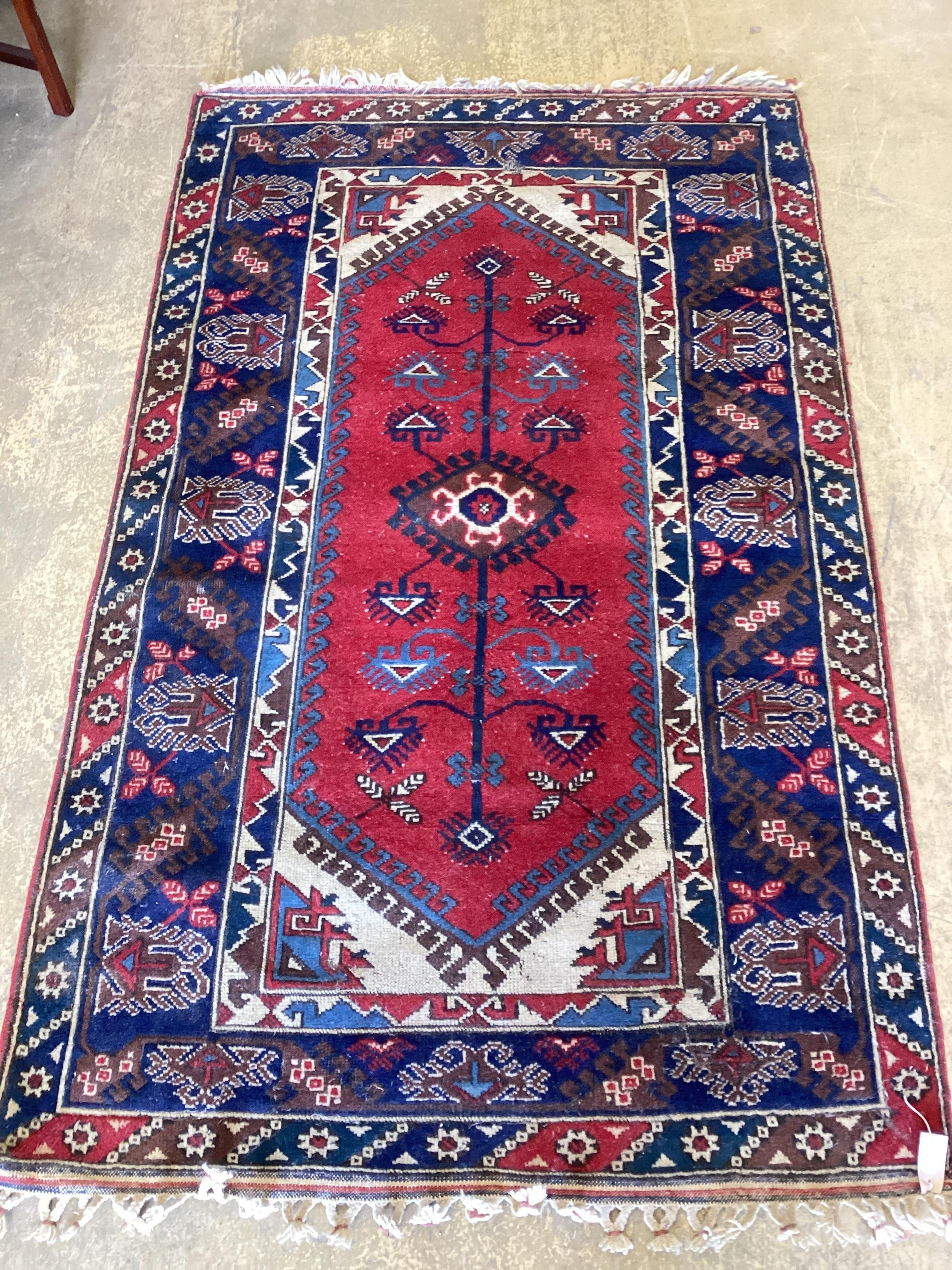 A Caucasian style red ground rug, 205 x 124cm